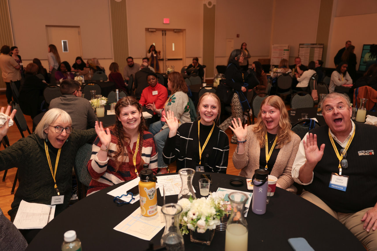 A group of guests laughing together at a banquet table.