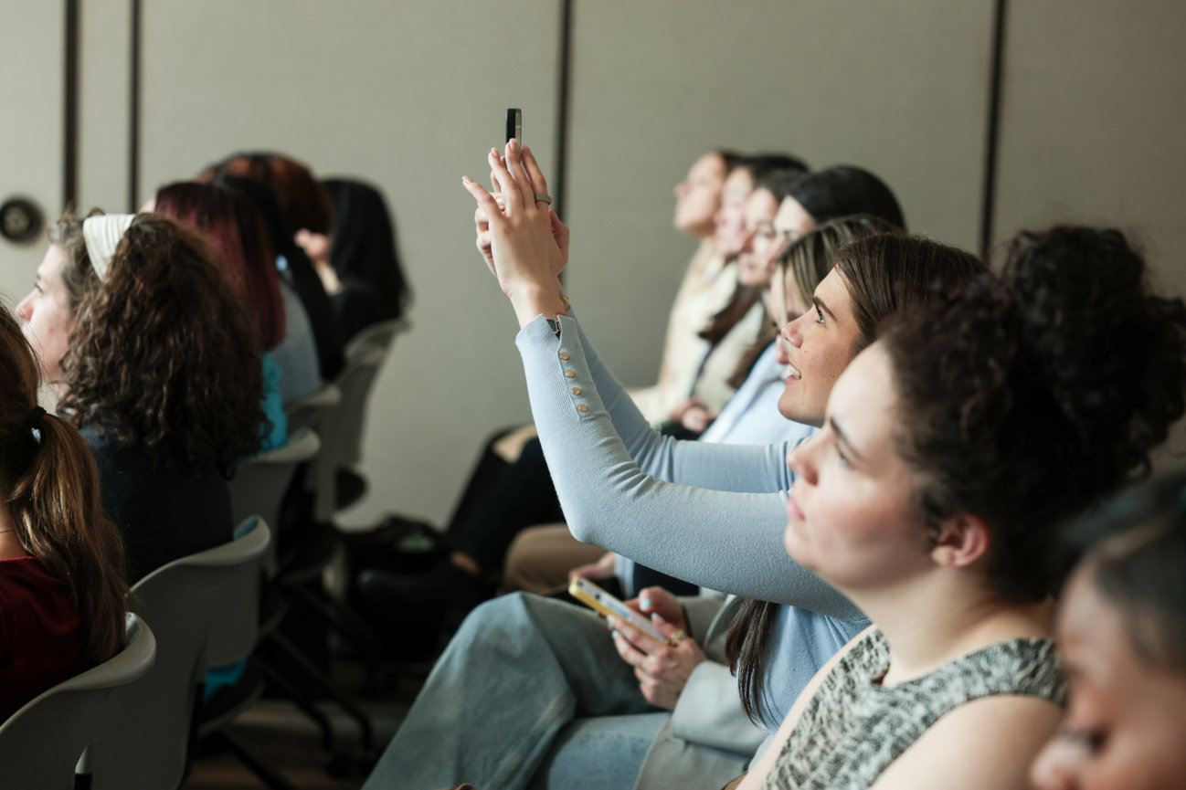 Audience members listen closely during an indoor presentation.