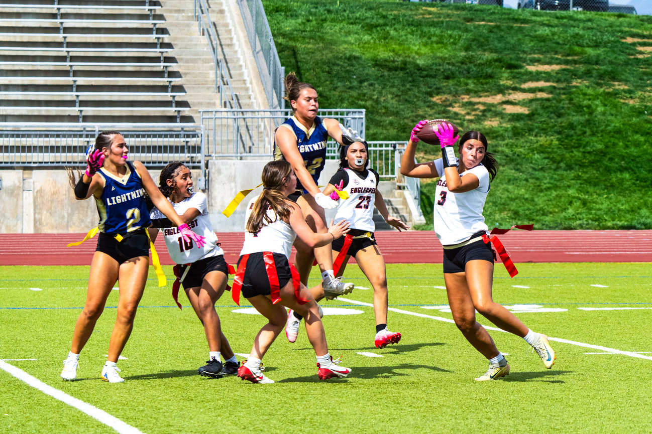 A group of flag football players celebrating together on the field.