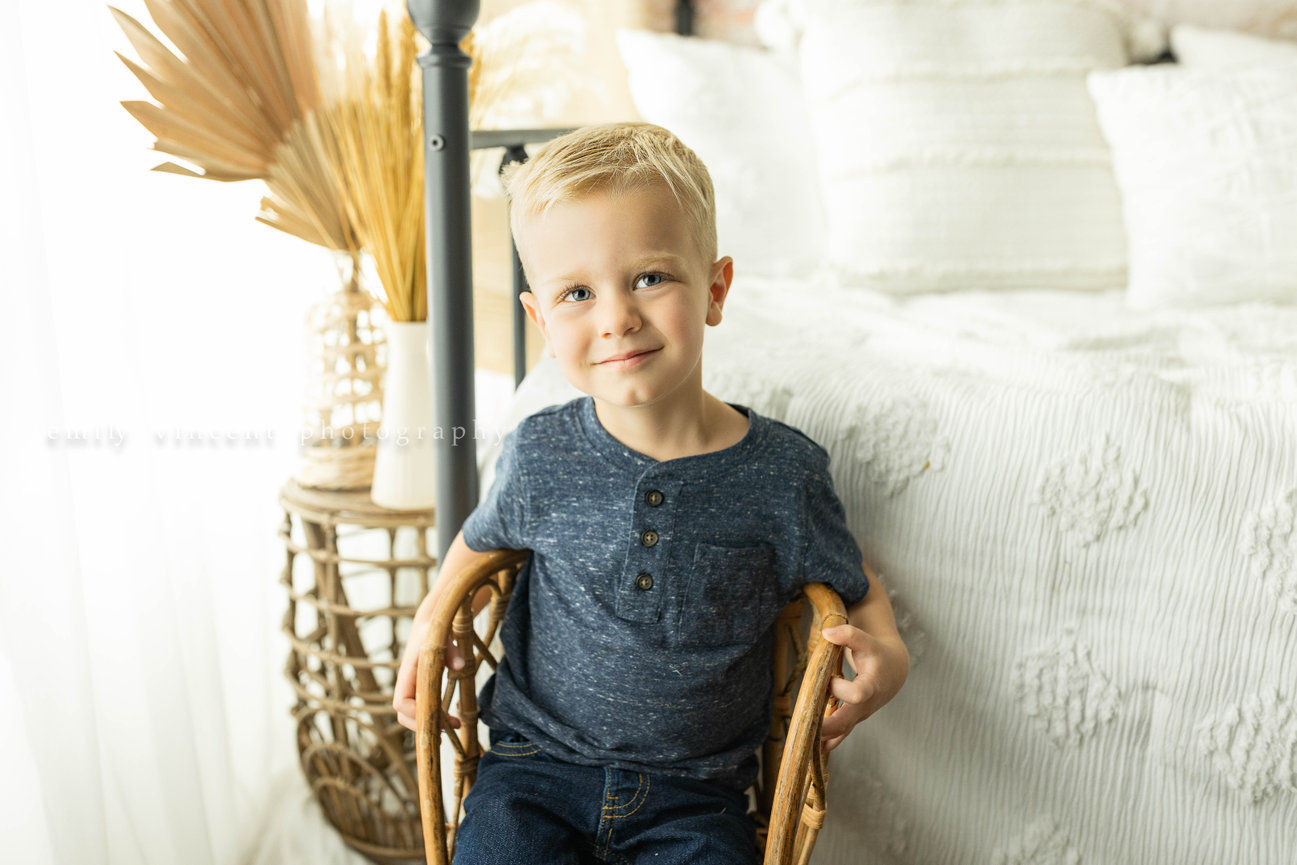 Young child sitting on chair during portrait session