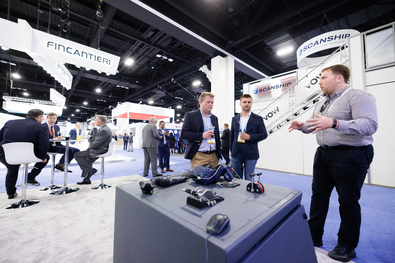 Trade show booth with men discussing technology displays and demo equipment