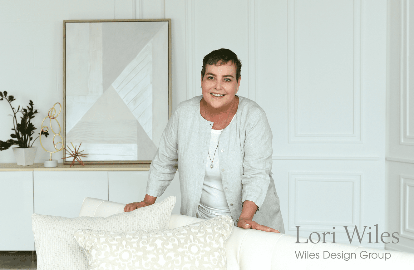 Interior designer, Lori Wiles, leans on a white couch for her business profile photo at Kliks Photography.