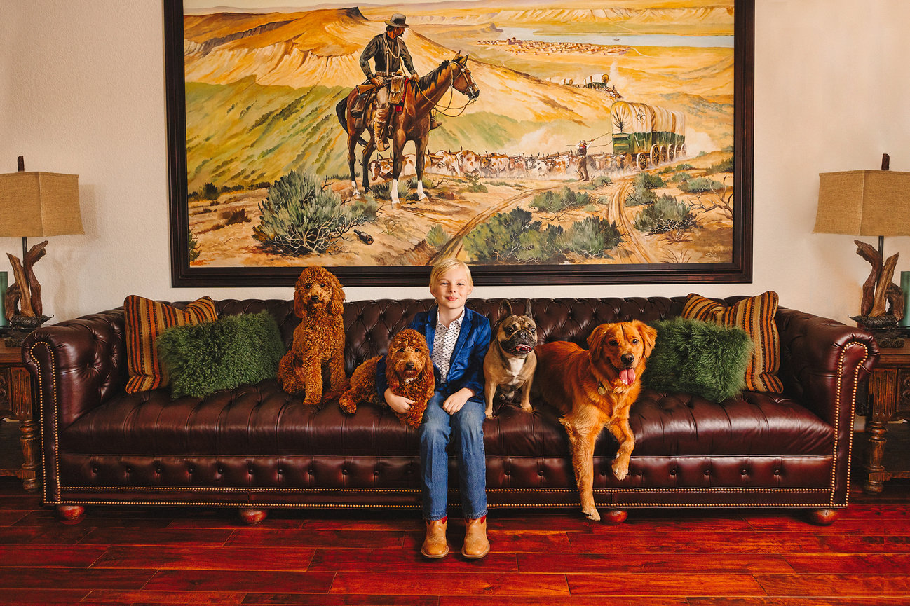 Portrait of a child with four dogs in a fort worth home.