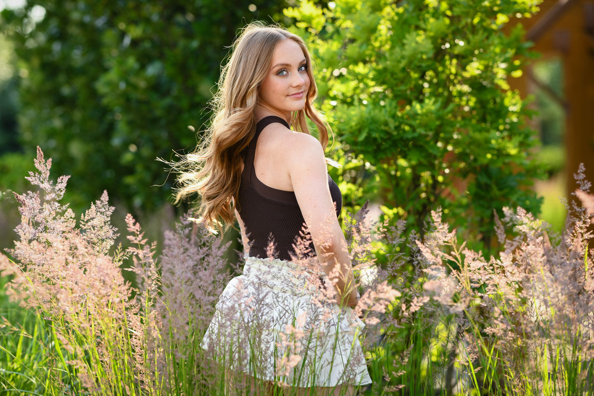 teenage girl with light curly hair in a black tank top and a skirt in a field at sunset in Dublin OH