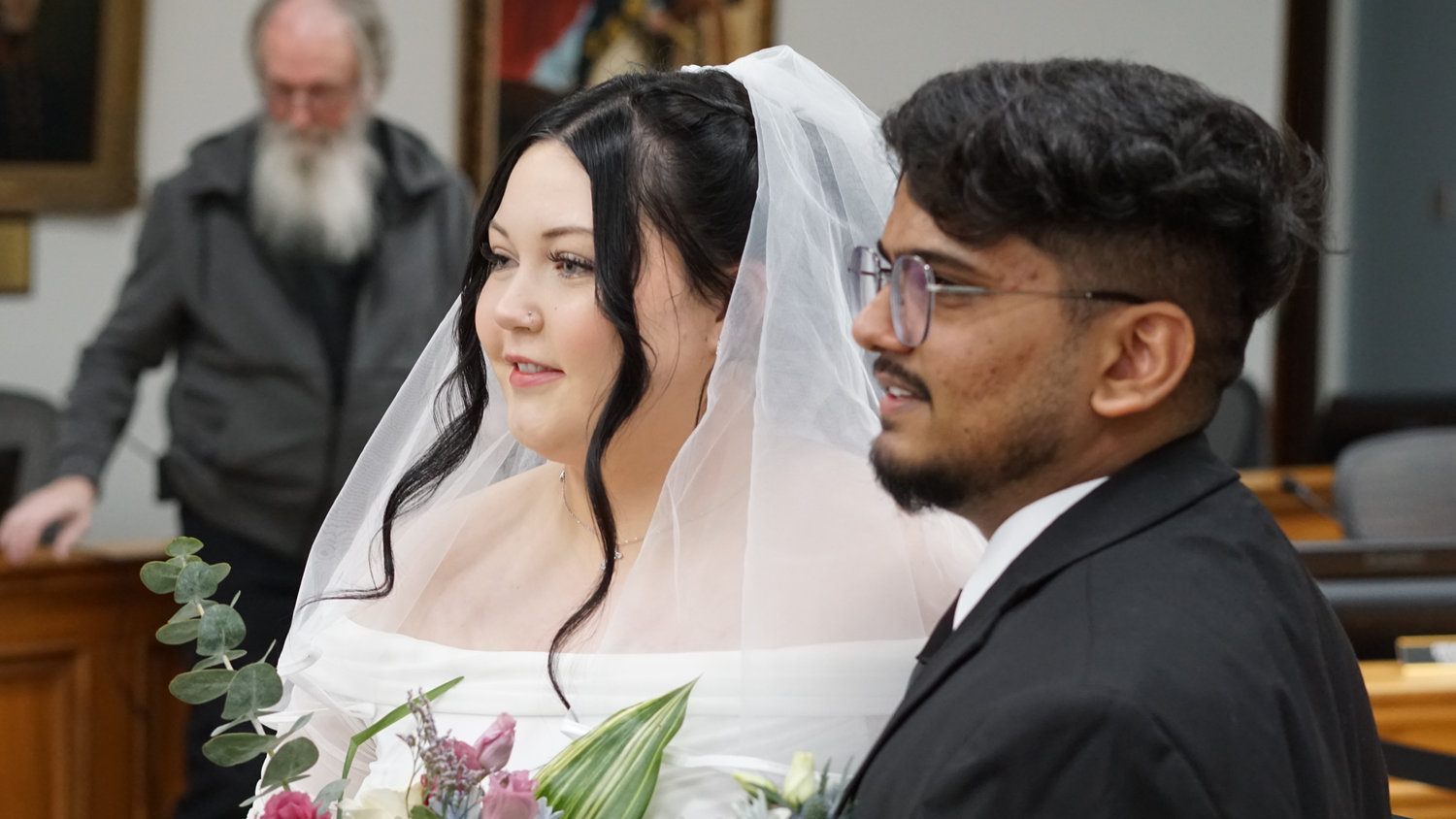 Bride and groom standing together holding a bouquet