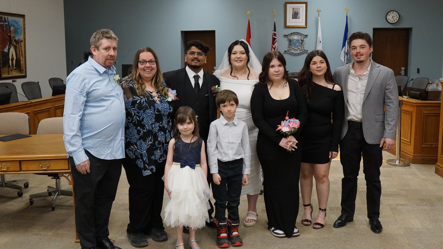 Wedding couple posing with family in a ceremony room